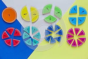 Colorful math fractions on wooden background or table. Geometry and