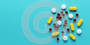 Colorful medical pills on blue background, assorted tablets close-up, top view. Heap of different dietary supplements. Beautiful