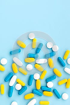 Colorful medical pills on blue background. Top view flat lay