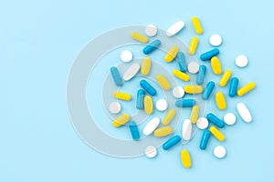 Colorful medical pills on blue background. Top view flat lay