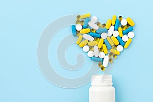 Colorful medical pills spilling out of a drug bottle