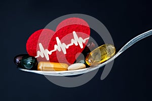 The colorful medical supplement and drug pills with red heart in