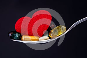 The colorful medical supplement and drug pills with red heart in