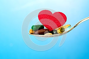 The colorful medical supplement and drug pills with red heart in