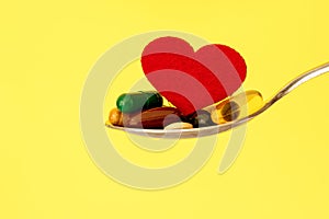 The colorful medical supplement and drug pills with red heart in