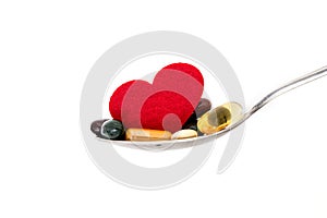 The colorful medical supplement and drug pills with red heart in