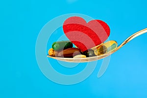 The colorful medical supplement and drug pills with red heart in