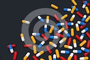 Colorful medicine capsules on black background, horizontal