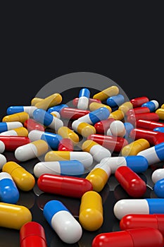 Colorful medicine capsules on black background, vertical