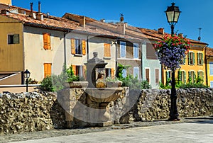 Colorful medieval facades with water fountain in Moustiers-Sainte-Marie