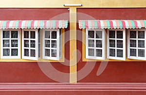 Colorful metal canopy on the wooden window.