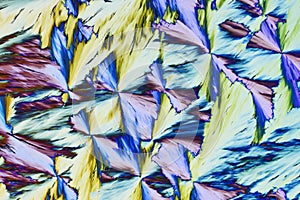 Colorful micro crystals in polarized light. Photo through a microscope