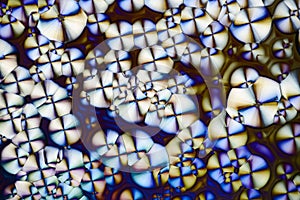 Colorful micro crystals in polarized light. Photo through a microscope