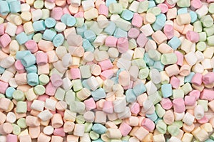 Colorful mini marshmallows in pastel colours background texture