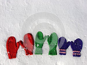 Colorful mittens on snow