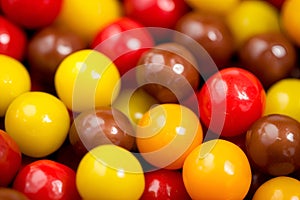 A colorful mix of shiny, round gummy candies, a visual treat in red, yellow, and brown