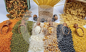 Colorful mixed cereals and legumes: rice, pasta, lentils, beans, chickpea on white background. Top view. Empty space for text
