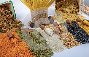 Colorful mixed cereals and legumes: rice, pasta, lentils, beans, chickpea on white background. Top view. Empty space for text