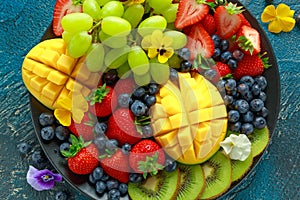 Colorful Mixed Fruit platter with Mango, Strawberry, Blueberry, Kiwi and Green Grape. Healthy food photo
