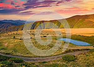 Colorful morning view of Carpathian mountains witj small lake and old country road, Ukraine, Europe