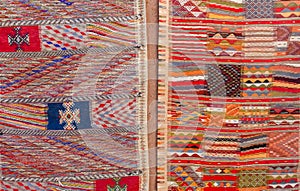 Colorful Moroccan Berber carpets hanging on adobe wall