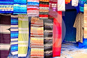 Colorful Moroccan fabrics and handmade souvenirs on the street in the blue city Chefchaouen, Morocco, Africa