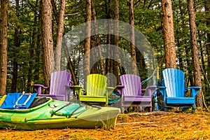 Colorful wooden chairs at rivers edge in the colors of Autumn, w