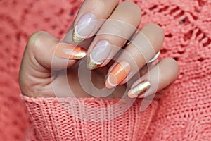 Colorful nail design with peach and golden nail polish