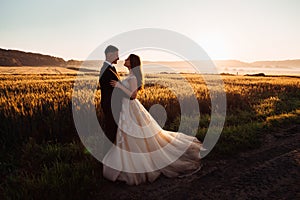 Colorful nature surrounds comely hugging wedding couple photo