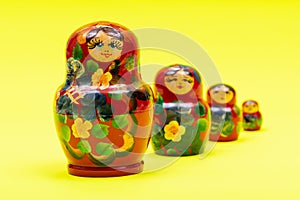 Colorful Nesting wooden Dolls isolated on bright yellow. National Russian souvenirs. Babushkas or Matryoshkas.