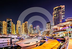 Colorful night dubai marina skyline. Luxury yacht dock. Dubai, United Arab Emirates.