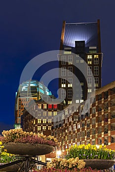 Colorful night shot of the Muzenplein with potted flowers in the foreground, The Hague, Netherlands