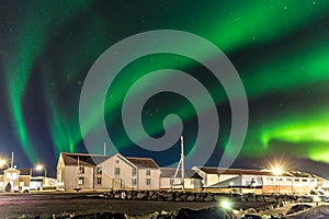 Colorful northern lights Aurora borealis with a warehouse in the foreground in Iceland
