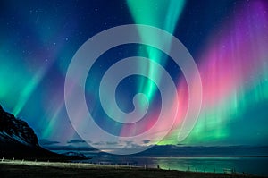 Colorful northern lights spiral in a Iceland beach