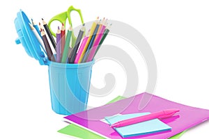 colorful note books, pen and miniature dustbin with desk supplies