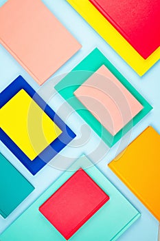 Colorful notebooks over the blue pastel background. Modern abstract working space