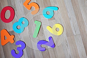 Colorful numbers on light brown wooden texture laminate floor background