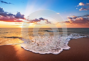 Colorful ocean beach sunrise with deep blue sky.