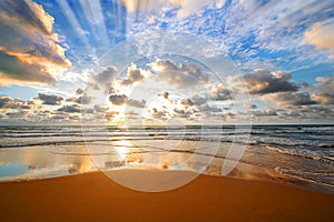 Colorful ocean beach sunrise with deep blue sky and sun rays