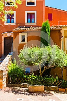 Colorful ochre houses and garden in the Roussillon village, Provence, France