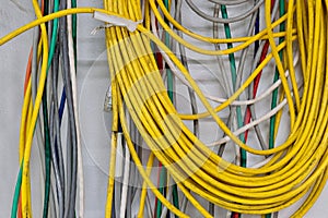 Colorful old electrical cables hanging on a wall.