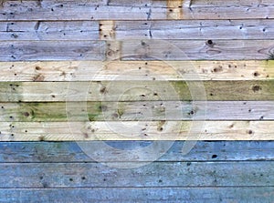 Colorful old rustic wooden plank wall or floor with some of the boards stained blue made of reused timber