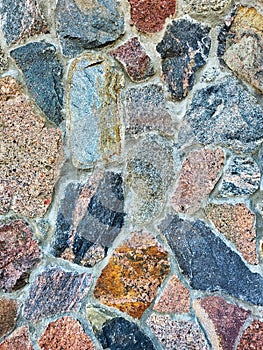 Colorful old stone wall texture background. Background of stone wall of boulders and pebbles. Stone in the beside of house. Black