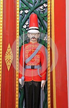 Colorful old style wooden door depicting, carved soldiers as Guardians on double doors at the entrance to an old temple