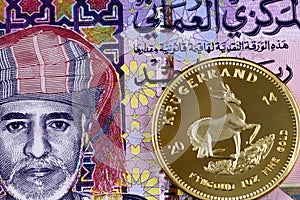 Colorful one Omani rial bank note with gold krugerrand coin