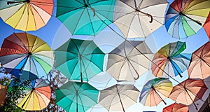 Colorful open umbrellas cover a street at Nicosia, Cyprus. Blue sky and parasols for backdrop.