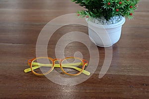 Colorful orage and yellow glasses and white flower pot on wooden photo