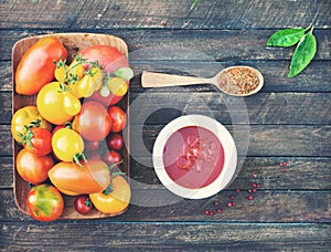 Colorful Organic Tomatoes in wooden plate with ketchup spices an