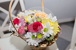 Colorful ornamental variety of flowers in the gift wood basket with roses , leaf and chrysanthemum, daisies,selective