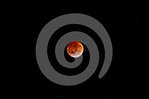 Eclipse lunar red full moon in dark black sky at night photo